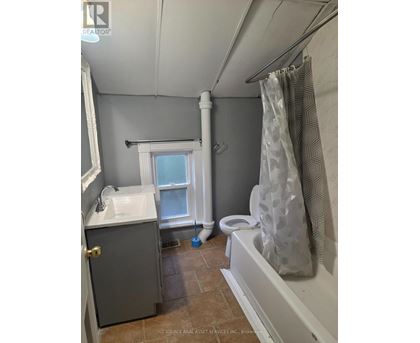 A bathroom with a toilet, sink, and shower.