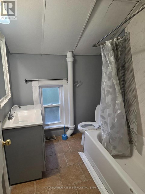 A bathroom with a toilet, sink, and shower.