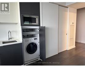 A modern kitchen with a washing machine built into the cabinetry.