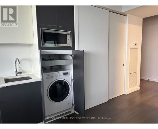 A modern kitchen with a washing machine built into the cabinetry.