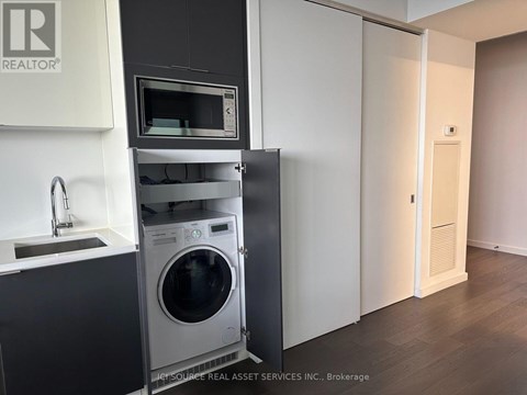 A modern kitchen with a washing machine built into the cabinetry.