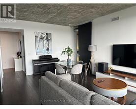 A living room with a grey couch, a wooden coffee table, and a television.