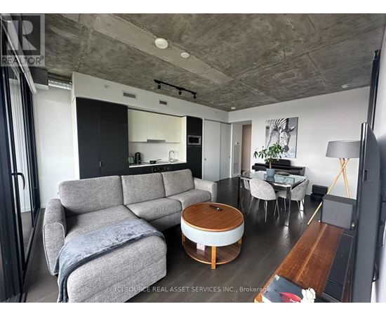 A living room with a grey couch and a wooden coffee table.