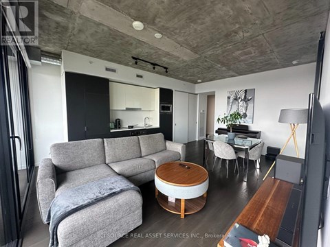 A living room with a grey couch and a wooden coffee table.