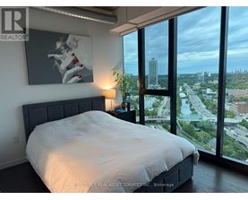 A bedroom with a large bed and a view of the city.