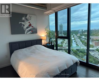 A bedroom with a large bed and a view of the city.