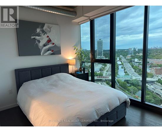 A bedroom with a large bed and a view of the city.