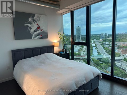 A bedroom with a large bed and a view of the city.