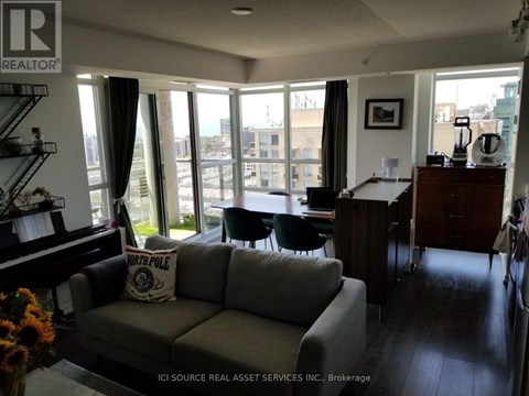 A living room with a grey couch and a piano.