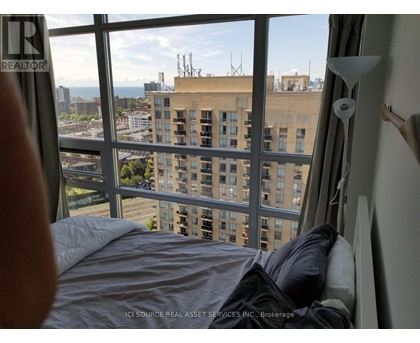 A bedroom with a large window overlooking a cityscape.