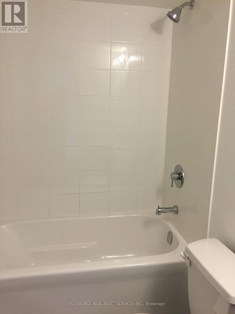 A white bathroom with a tub and toilet.