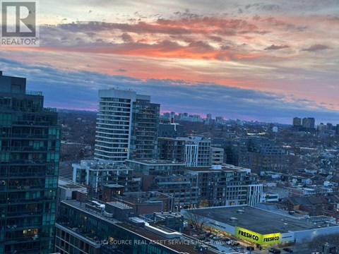 A cityscape with buildings and a Freshco store.