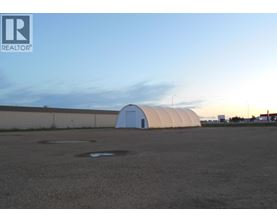 A large white dome structure sits in the middle of a parking lot.