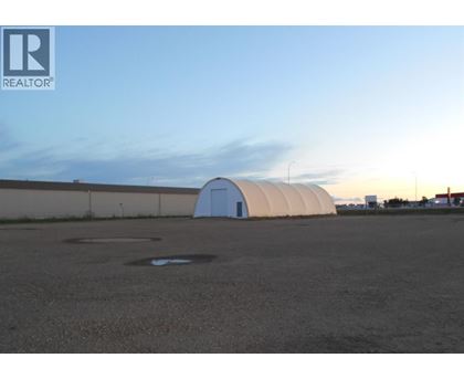 A large white dome structure sits in the middle of a parking lot.