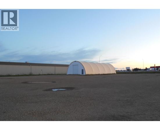 A large white dome structure sits in the middle of a parking lot.