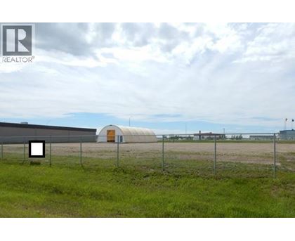 A fenced field with a building in the distance.