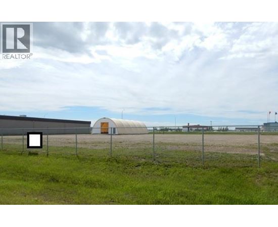 A fenced field with a building in the distance.
