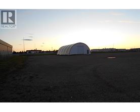 A large white dome structure sits in the middle of a dark parking lot.