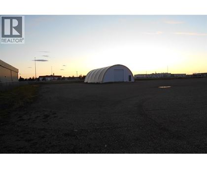 A large white dome structure sits in the middle of a dark parking lot.