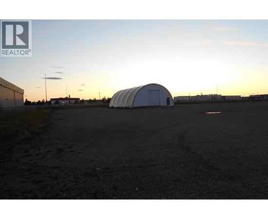 A large white dome structure sits in the middle of a dark parking lot.