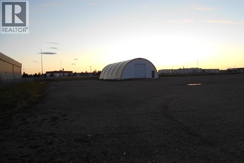 A large white dome structure sits in the middle of a dark parking lot.