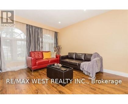A living room with a red chair and a black couch.