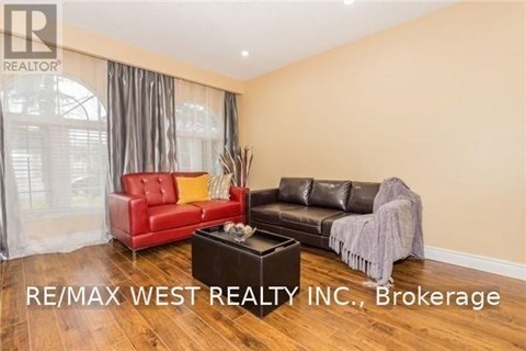 A living room with a red chair and a black couch.