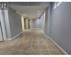 A long, empty hallway with tiled flooring and white walls.