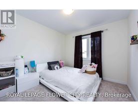 A bedroom with a white bed and a window with brown curtains.