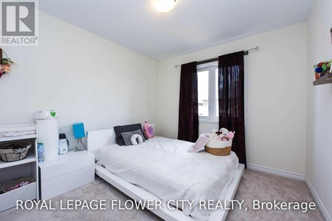 A bedroom with a white bed and a window with brown curtains.