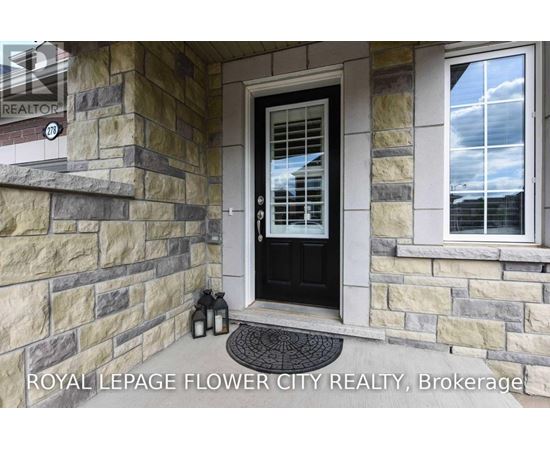 A house entrance with a black door and a stone wall.