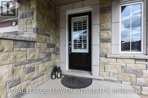 A house entrance with a black door and a stone wall.