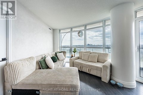 A living room with two couches and a large window.