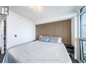A bedroom with a large bed and a window with blinds.