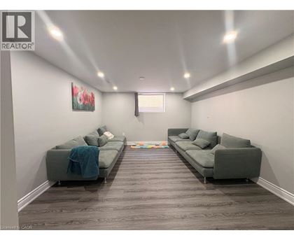 A living room with two grey couches and a painting on the wall.