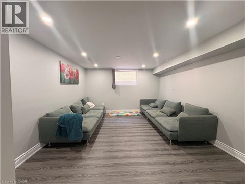 A living room with two grey couches and a painting on the wall.