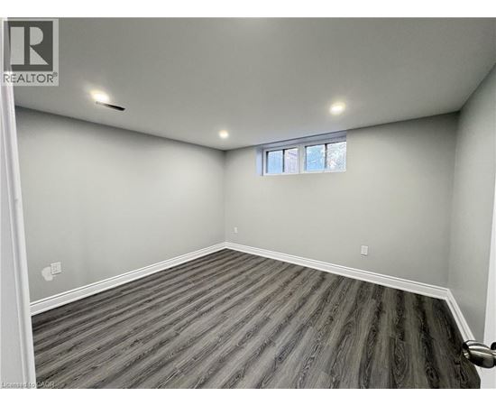A room with wooden flooring and a window.