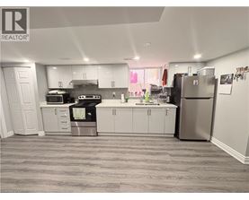 A kitchen with white cabinets and a grey floor.
