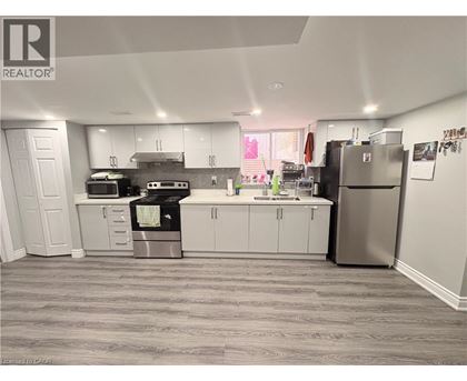 A kitchen with white cabinets and a grey floor.