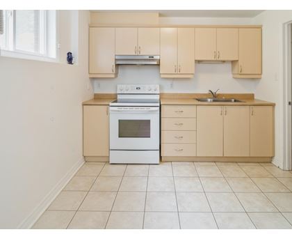 A kitchen with a white oven and beige cabinets.