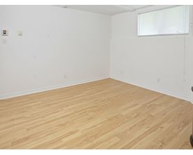 A room with wooden flooring and white walls.