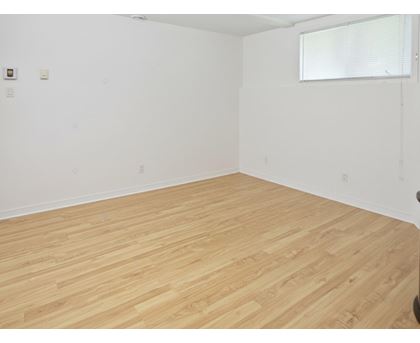 A room with wooden flooring and white walls.