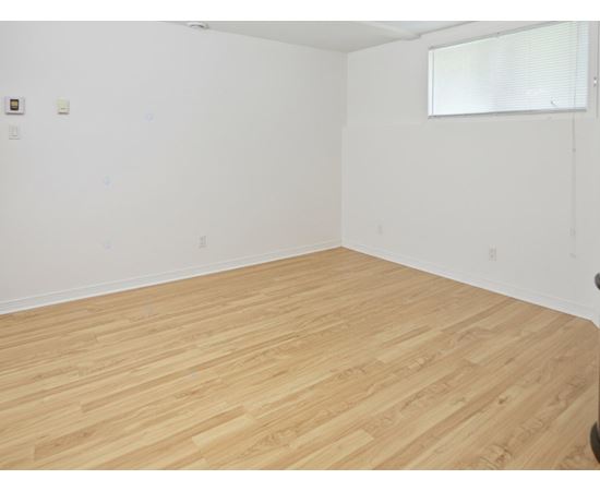 A room with wooden flooring and white walls.