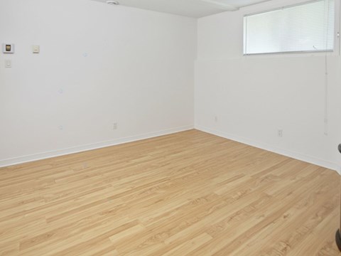 A room with wooden flooring and white walls.