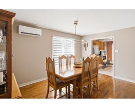 A dining room with a wooden table and chairs.