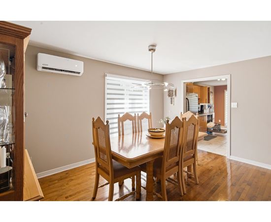 A dining room with a wooden table and chairs.