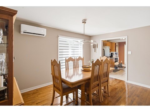 A dining room with a wooden table and chairs.