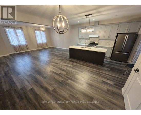 A spacious kitchen with wooden flooring and a large island.