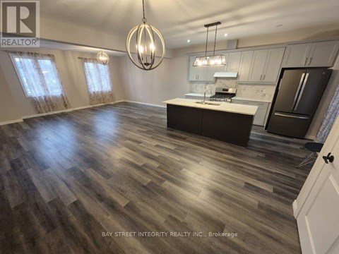 A spacious kitchen with wooden flooring and a large island.