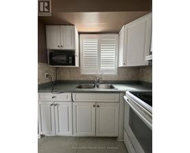 A kitchen with white cabinets and a stove top oven.